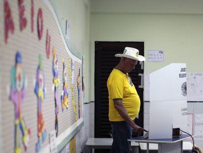 Um homem com camiseta amarela vota em uma escola em Brasília.