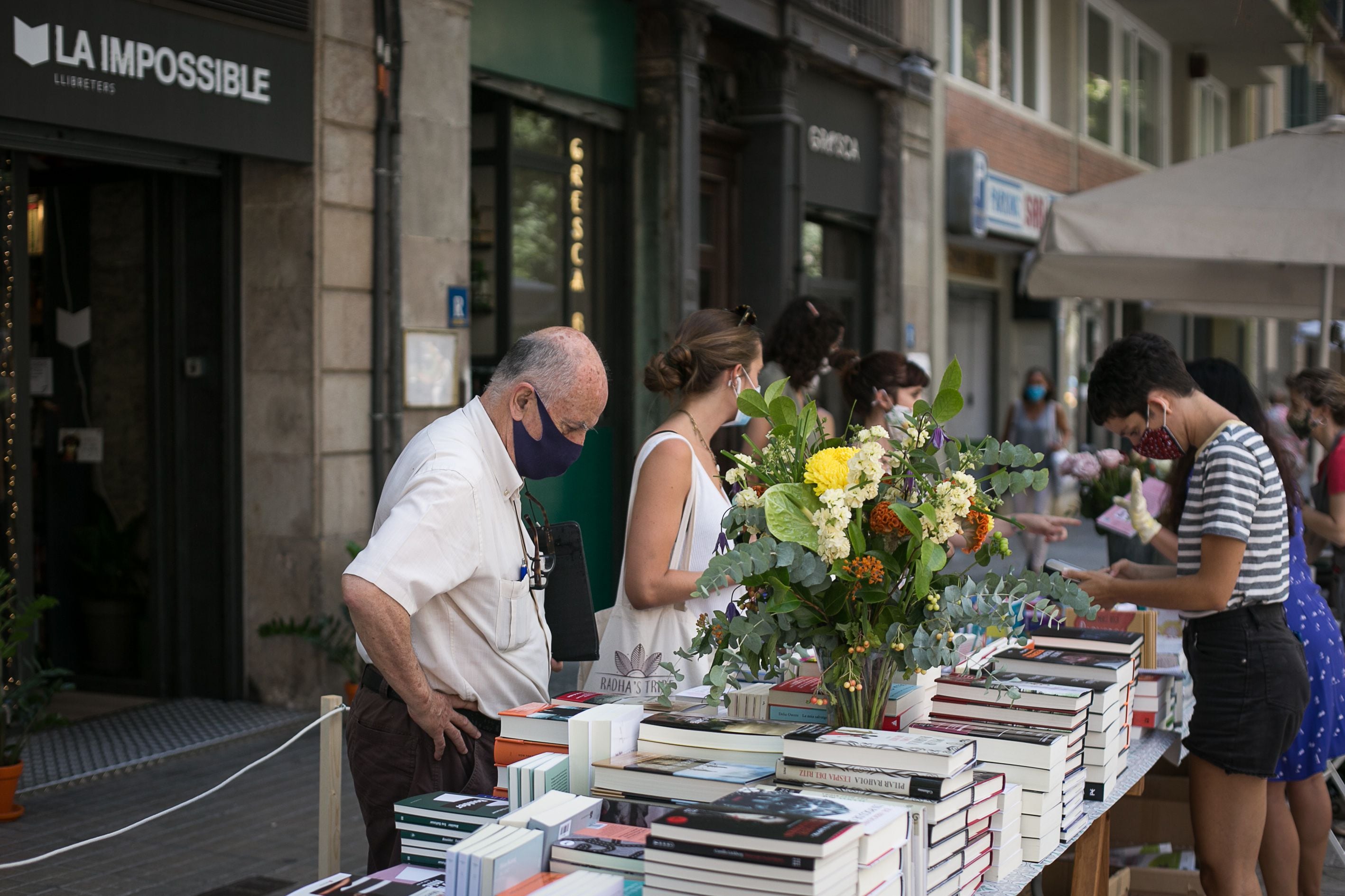 Em Barcelona, compradores em uma banca de livros e flores, nesta quinta-feira. Catalunha é uma das regiões mais afetadas por segunda onda do coronavírus.