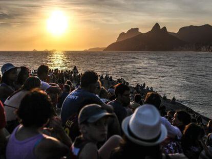 Pessoas observam o pôr do sol na pedra do Arpoador, no Rio de Janeiro.