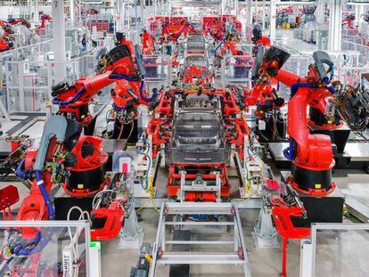 Um linear de robôs montam um carro na planta de Tesla em Fremont