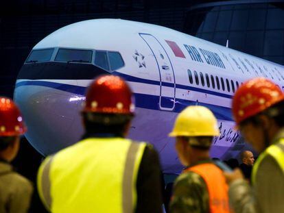 Grupo de trabalhadores diante de um Boeing 737 Max 8 da Air China, em uma imagem de arquivo. Em vídeo, morrem os 157 ocupantes da aeronave acidentada.