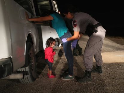 Menina hondurenha chora enquanto sua mãe é revistada pela patrulha fronteiriça em McAllen (Texas), em 2018.