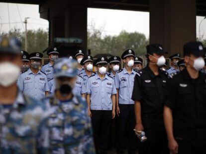 Soldados e policiais chineses participam de homenagem às vítimas na terça.