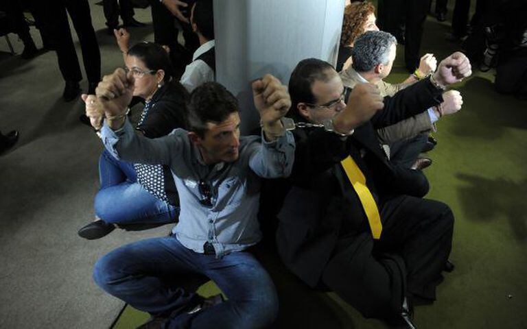 Manifestantes se acorrentam em torno de pilastra no Salão Verde da Câmara dos Deputados para pressionar Eduardo Cunha a encaminhar pedido de impeachment de Dilma Rousseff.