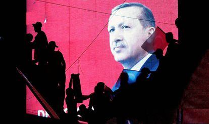 Apoiadores de Erdogan diante de telão.