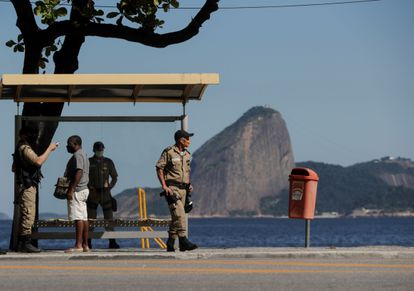 Um oficial de segurança mede a temperatura de um homem nesta segunda-feira em Niterói, uma das primeiras cidades do Rio de Janeiro a endurecer as medidas restritivas.