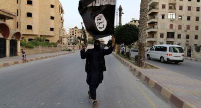 Em junho de 2014, um membro armado do Estado Islâmico acenando uma bandeira na cidade síria de Raqqa, reduto da organização jihadista.