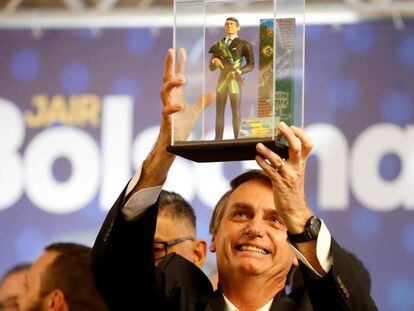 Jair Bolsonaro segura um boneco que o representa em Curitiba no dia 29 de março.