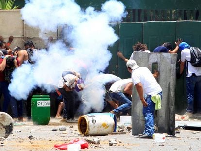 Manifestantes se protegem durante os protestos na Universidade Agrária de Manágua.