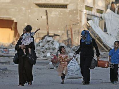 Palestinos caminham para um abrigo da ONU, em Gaza.