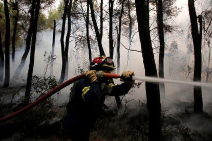 Um bombeiro luta contra o fogo na região de Kryoneri, ao norte de Atenas, na quinta-feira passada.