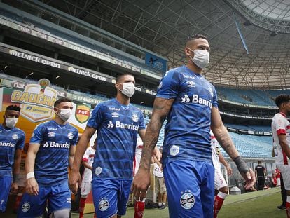 Jogadores do Grêmio entram em campo com máscaras como forma de protesto.