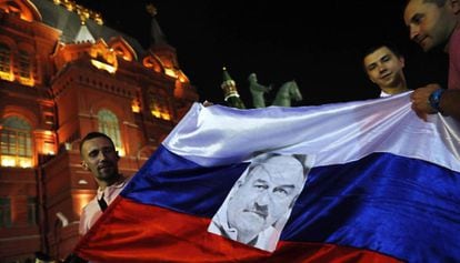 Com uma bandeira da Rússia e uma foto do técnico Stanislav Cherchesov, torcedores da seleção russa de futebol comemoram em Moscou a vitória contra a Espanha na Copa.