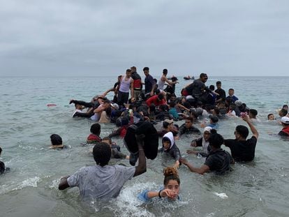 Um grupo se apropria de uma embarcação das autoridades marroquinas na praia da localidade de Fnideq para atravessar os quebra-mares de Ceuta, na terça-feira. Em vídeo, imagens das chegadas em balsas improvisadas nesta quarta.
