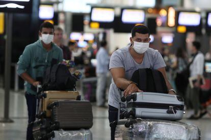 Passageiros usando máscaras de precaução caminham pelo aeroporto de Guarulhos, em São Paulo, no dia 3 de fevereiro.