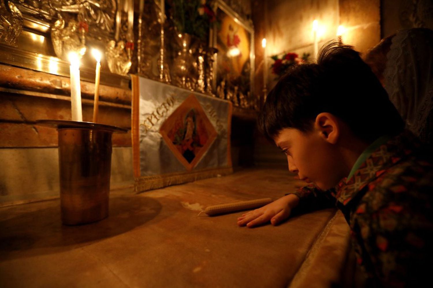 Menino reza na Igreja do Santo Sepulcro, na Cidade Velha de Jerusalém.