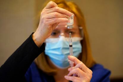 Funcionária do condado de Chester (Pensilvânia) enche uma seringa com uma dose da vacina da Moderna para aplicar em profissionais da saúde.