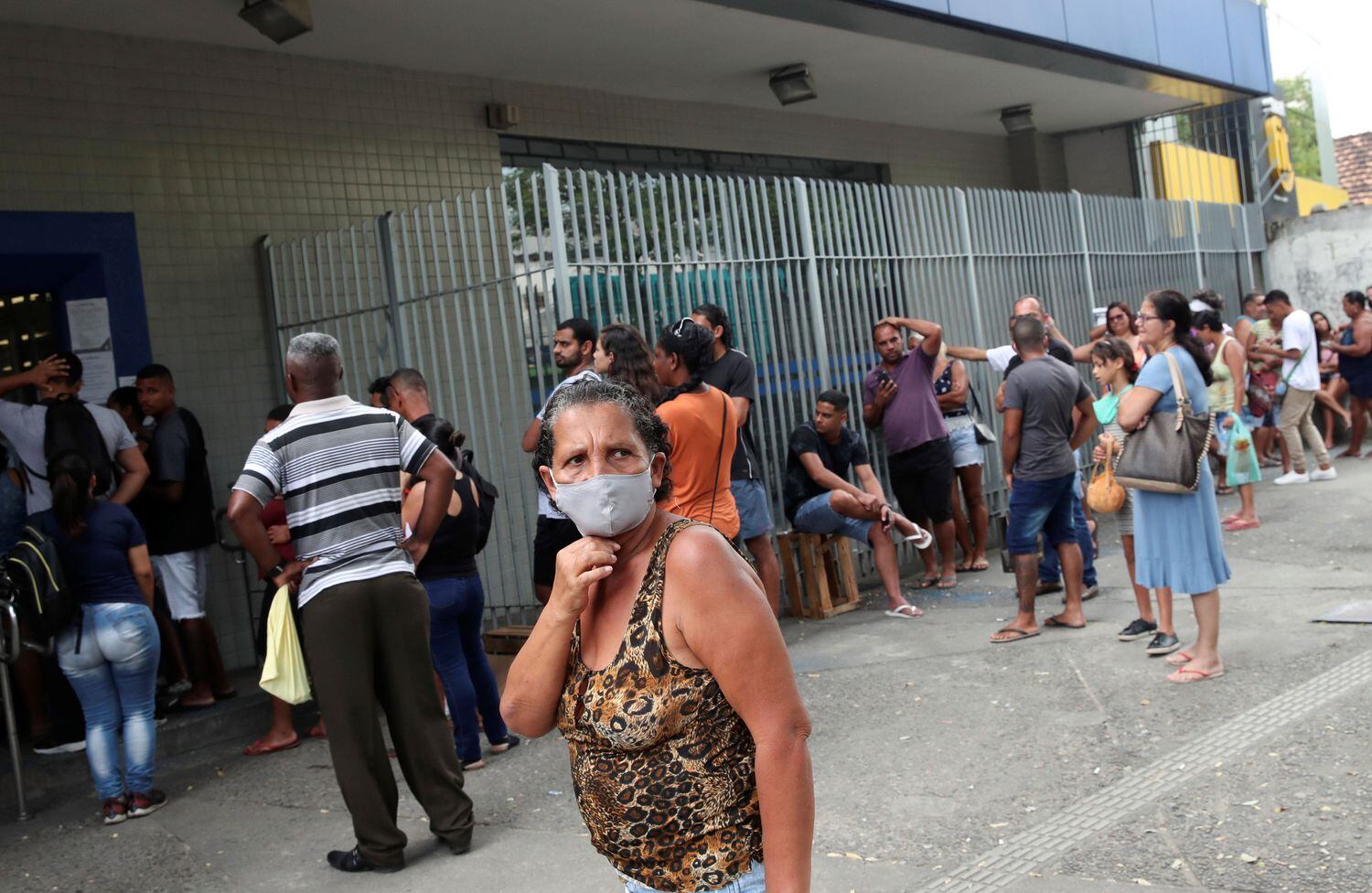 Dezenas de pessoas fazem fila em frente a uma unidade da Caixa, nesta quarta-feira no Rio de Janeiro, para tentar receber o auxílio emergencial anunciado pelo Governo.
