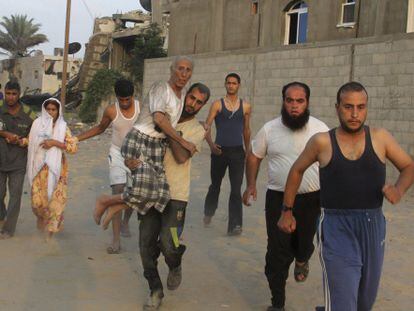 Moradores correm em busca de refúgio na Faixa de Gaza. / Hatem Ali (AFP)