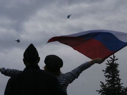 Uma mulher hasteia uma bandeira russa em Sebastopol.