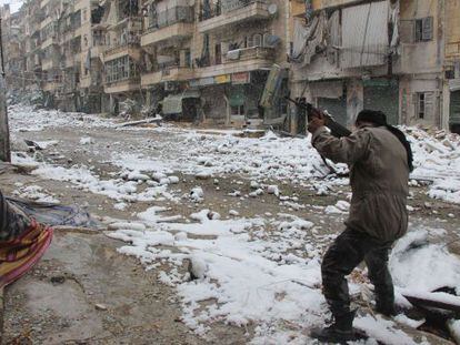 Um rebelde aponta seu rifle em uma rua de Alepo, na Síria.
