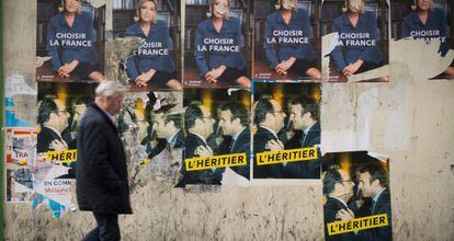 Um homem passeia em frente a cartazes com propaganda eleitoral na sexta-feira, em Paris.