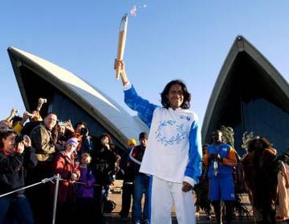 Cathy Freeman com a tocha olímpica diante da Ópera de Sydney .