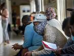 Volunteers wait to be checked at a vaccine trial facility set at Soweto's Chris Sani Baragwanath Hospital outside Johannesburg, South Africa, Monday Nov. 30, 2020. Over 2000 South African volunteers are on AstraZeneca's experimental coronavirus vaccine trial. (AP Photo/Jerome Delay)