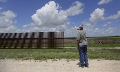 Homem aponta para trecho de cerca na fronteira em Brownsville (Texas), em uma imagem de 2005