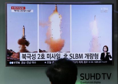 Homem vê uma televisão que transmite imagens do lançamento de um míssil na Coreia do Norte.