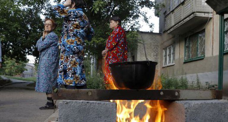 Um grupo de mulheres ferve água em uma rua de Slaviansk.