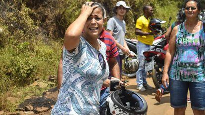 Mulher chora ao observar os estragos causados pelo rompimento da barragem em Brumadinho.