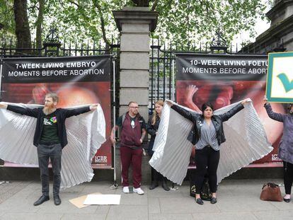 Ativistas pelo 'sim' tentam tampar cartazes contra o aborto em Dublin.