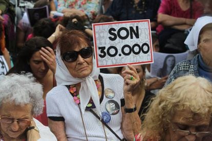 Uma mulher segura um pôster que faz referência aos 30.000 desaparecidos enquanto escuta a leitura do veredicto pelos crimes cometidos na Escola de Mecânica da Armada (ESMA).