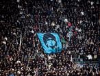 (FILES) In this file photo taken on January 07, 2013 SSC Napoli's fans display a flag with the effigy of Napoli's former Argentinian player Diego Armando Maradona during the Serie A football match SSC Napoli vs A.S. Roma at San Paolo Stadium in Naples. - Argentinian football legend Diego Maradona passed away on November 25, 2020. (Photo by ROBERTO SALOMONE / AFP)
