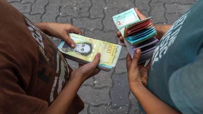 Duas crianças contam dinheiro em Caracas.