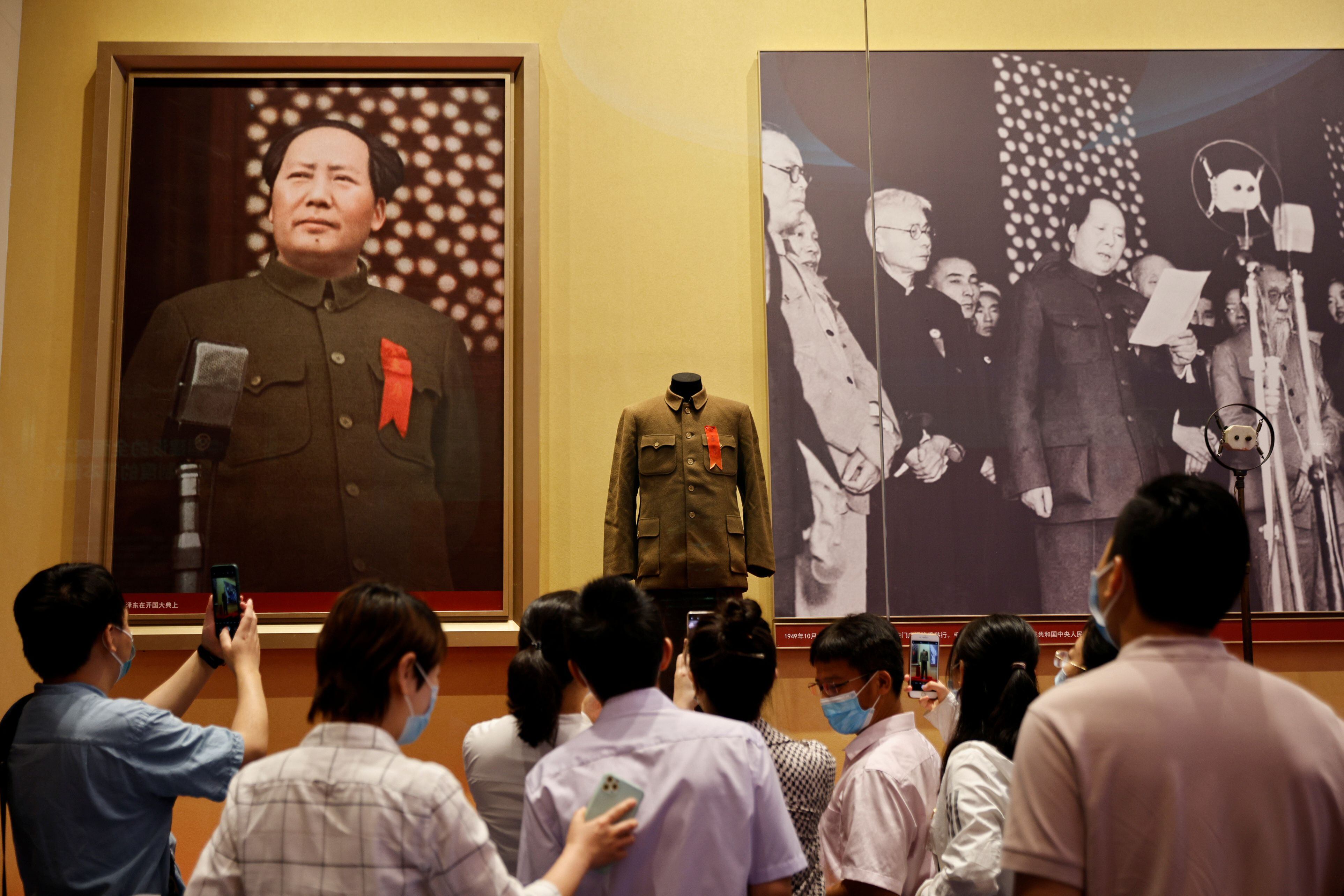 Um grupo de pessoas contempla imagens de Mao Tsé-tung no Museu de História do Partido Comunista da China, em Pequim. 