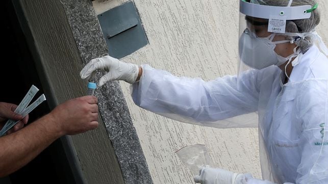Homem recebe na terça, 14 de abril, um teste de coronavírus de um profissional da saúde na porta de sua casa, em São Caetano do Sul, São Paulo.
