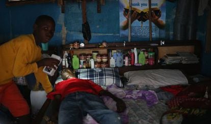 Um menino prepara o pai, com suspeita de ebola, para ser levado a um centro de isolamento.