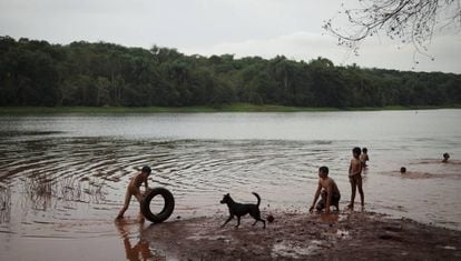 Crianças nadam no rio Paraná. A administração de Itaipu proibiu a comunidade de pescar na represa.