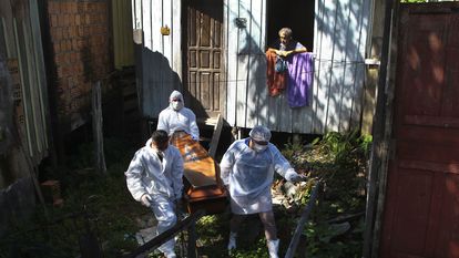 Funcionários municipais recolhem o corpo de uma nonagenária que morreu por complicações da covid-19 em sua casa em Manaus na última sexta-feira.