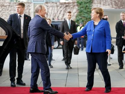O presidente russo, Vladimir Putin, e a chanceler alemã, Angela Merkel, cumprimentam-se em Berlim, em janeiro de 2020, no início de uma conferência sobre a Líbia.
