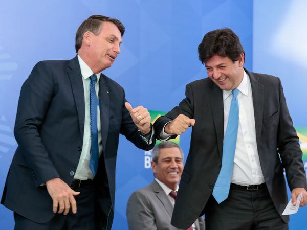 O presidente Jair Bolsonaro faz cumprimento de cotovelo com o ex-ministro Luiz Henrique Mandetta em cerimônia no Palácio do Planalto.