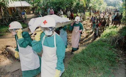 Membros da Cruz Vermelha transportam o cadáver de uma vítima de ebola, em 1995, perto de Kikwit, no Zaire.