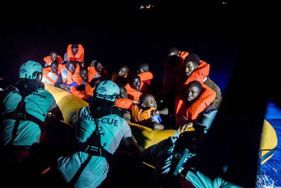 Membros de SOS Mediterranée resgatam migrantes na noite deste sábado.