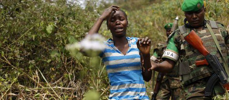 Uma mulher aterrorizada é conduzida por um soldado nos arredores de Bangui, capital da República Centro-Africana.