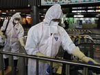 Los trabajadores de desinfección que usan trajes protectores rocían una solución antiséptica en una terminal de trenes en medio de las crecientes preocupaciones públicas sobre la propagación del coronavirus Wuhan de China en la estación de trenes en Seúl, Corea del Sur