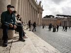 People sit by Bernini's colonnade in St. Peter's Square at the Vatican, Friday, March 6, 2020. A Vatican spokesman has confirmed the first case of coronavirus at the city-state. Vatican spokesman Matteo Bruni said Friday that non-emergency medical services at the Vatican have been closed so they can be sanitized following the positive test on Thursday. (AP Photo/Andrew Medichini)
