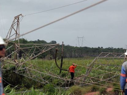 Técnicos ao lado de torre de transmissão de energia destruída no Ceará.