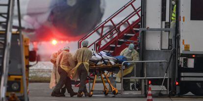 Agentes de saúde fazem a transferência de um paciente com coronavírus a outra unidade de UTI do país em um avião militar nesta sexta-feira, em Memmingen.